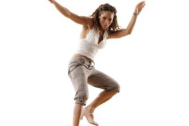 A women wearing a white tank top and khaki knee length pants tap dancing